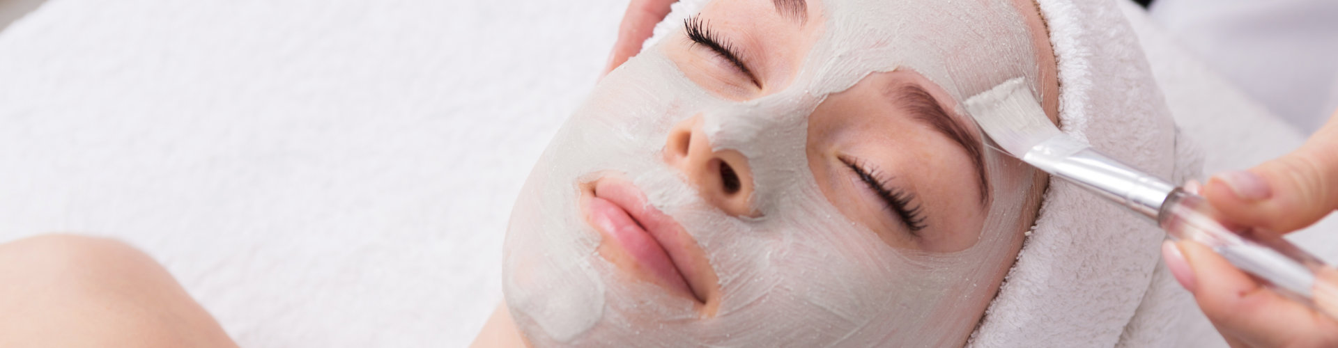 woman applying skin care product to woman's face