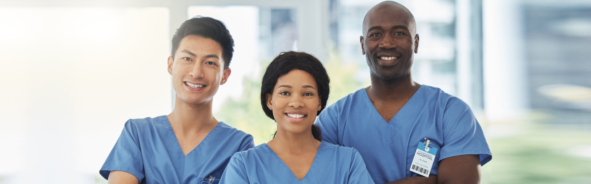 Diverse team of smiling healthcare workers in blue scrubs.