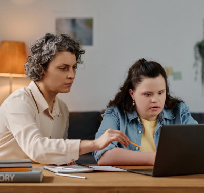 Tutor teaching girl with down syndrome at home
