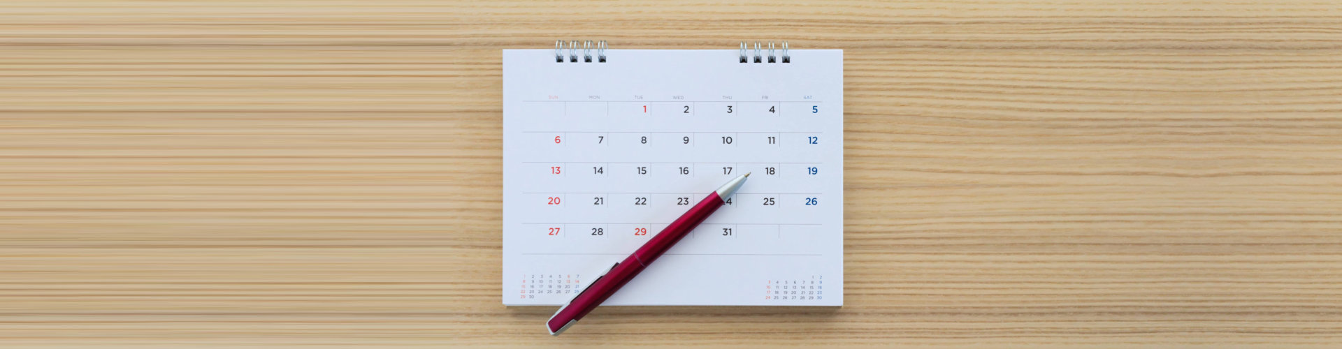 calendar and pen on a wooden table