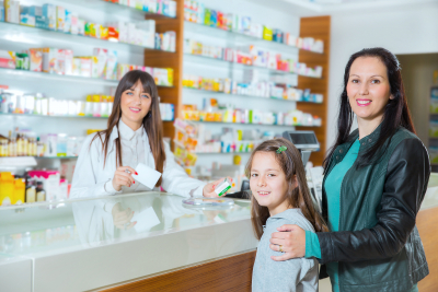 pharmacist giving vitamins to child girl in drugstore