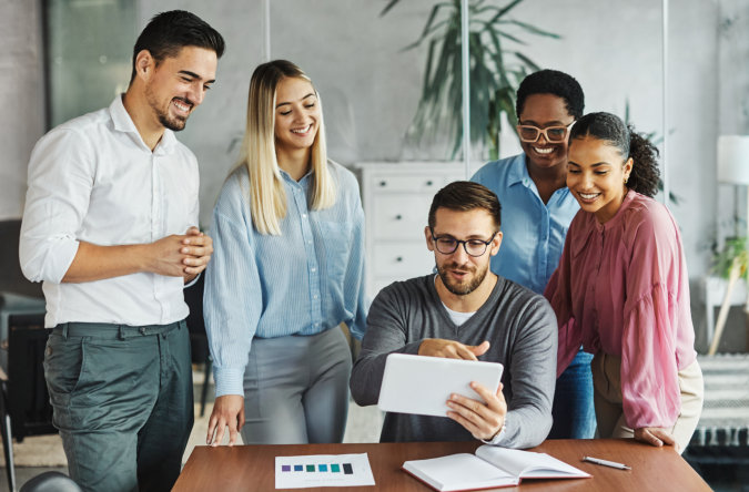 group of people smiling and looking at the gadget