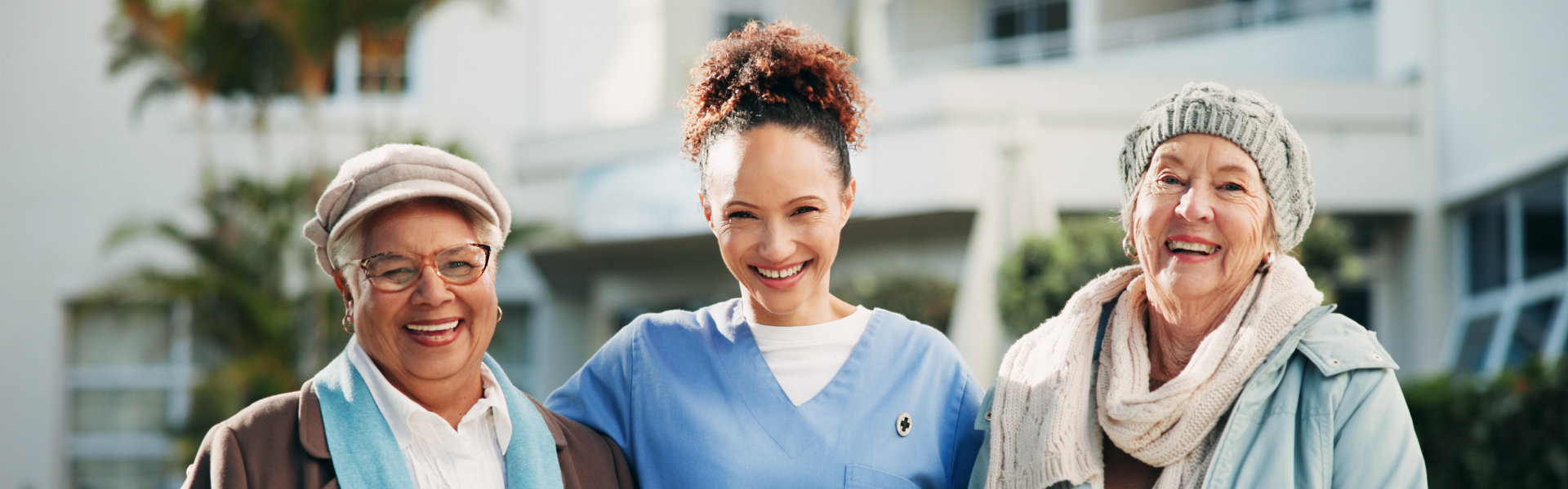 aide and two senior woman smiling